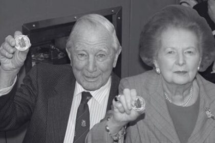 sir-rex-hunt,-el-gobernador-de-malvinas-que-fue-exiliado-por-galtieri-en-pijama,-con-una-botella-de-ginebra-y-el-retrato-de-la-reina