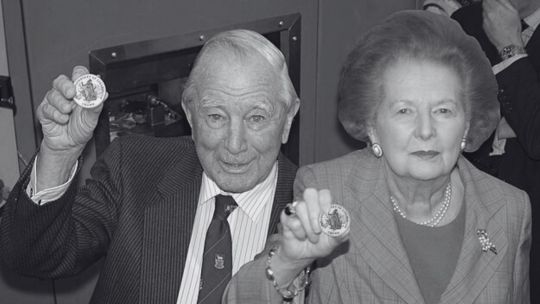 sir-rex-hunt,-el-gobernador-de-malvinas-que-fue-exiliado-por-galtieri-en-pijama,-con-una-botella-de-ginebra-y-el-retrato-de-la-reina