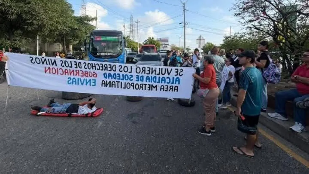 padres-de-familia-de-cuatro-colegios-bloquean-la-calle-30-y-trancan-la-via-al-aeropuerto-en-barranquilla-por-un-puente-peatonal-en-ruinas
